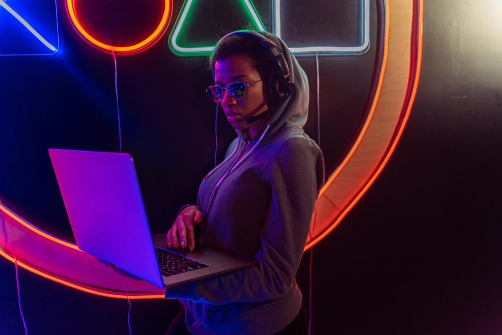 Woman with headset using a laptop against a neon backdrop, showcasing digital privacy.